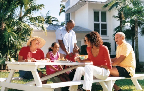 Family Sitting Outdoors Enjoying a Meal