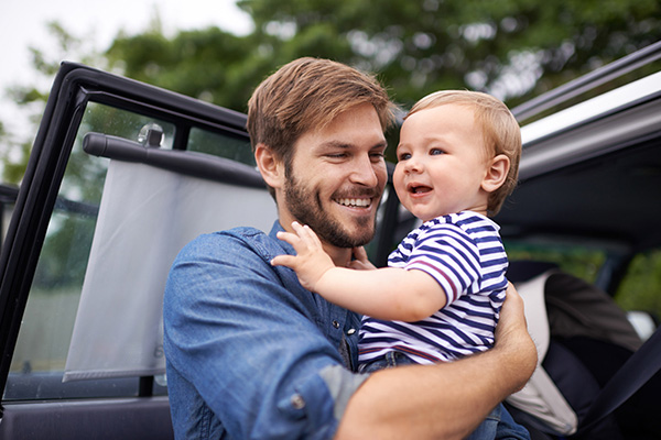 father taking baby son out of car