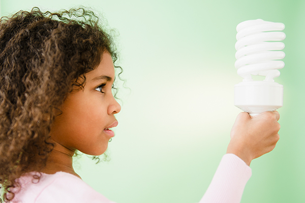 young girl holding energy-saving lightbulb