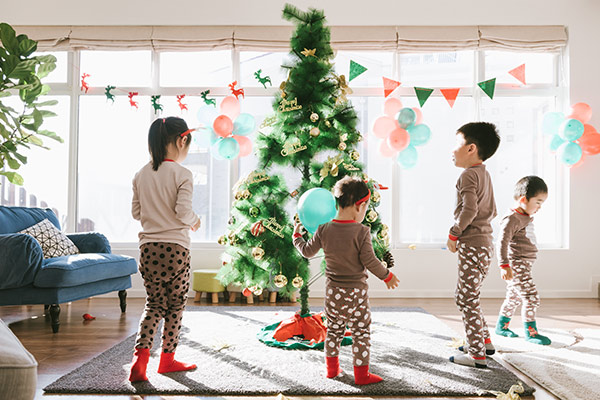 kids playing around a christmas tree