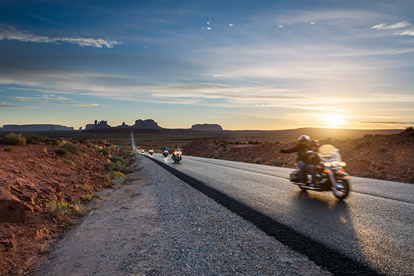 motorcycles riding down a desert road