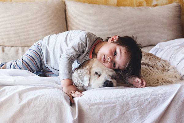 child cuddling dog