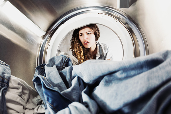 young woman looking into washing machine