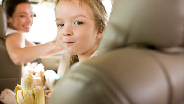 Girl eating banana in car