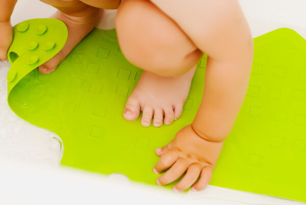 Baby feet in bathtub on anti slip rubber mat for bathroom