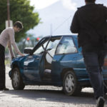 man helping a woman after a car accident