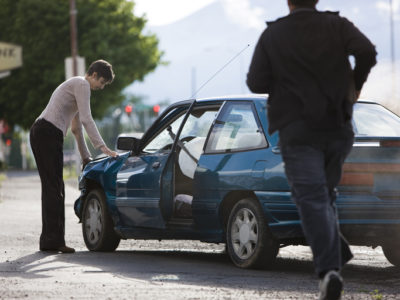 man helping a woman after a car accident