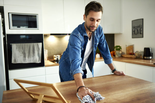 Man wiping table in kitchen
