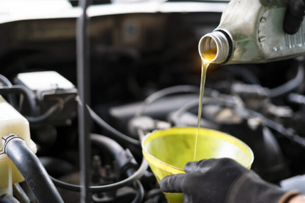 Close Up Of Pouring Lubricant Oil Into Engine