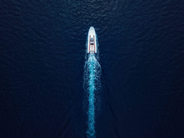 High angle view of a speed boat in motion surrounded by deep blue sea.