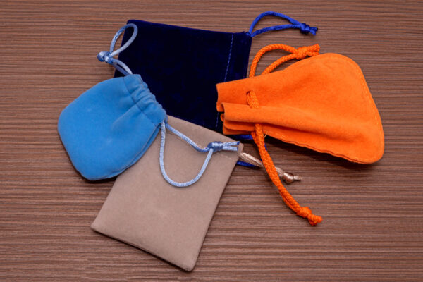 Velvet colorful pouches used as jewelry bags on wooden table
