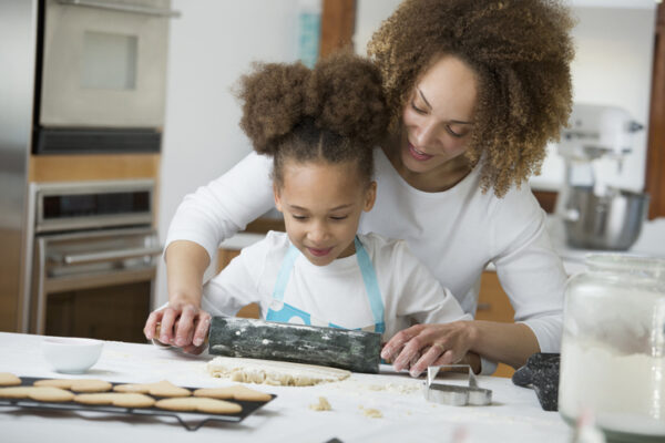 Black mother and daughter baking together