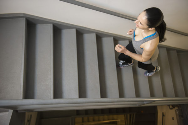 Caucasian woman running up stairs