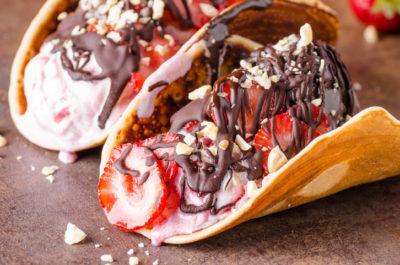 Homemade tacos with ice cream, nuts and chocolate, delicious strawberries