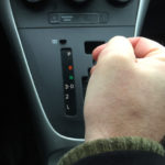Man switching gear of automatic transmission, on the road