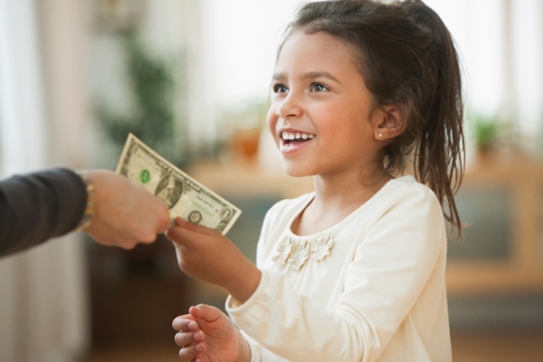 Mother handing girl one dollar bill