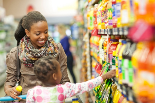 young mom shopping with daughter at grocery store