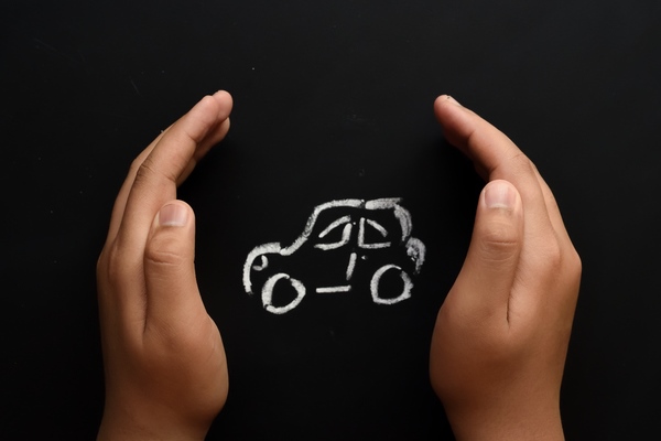 hands protecting chalk drawing of car