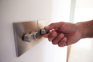 Close Up Shot Of Man Turning Down Electrical Dimmer Switch