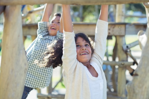 boy and girl playing on monkey bars