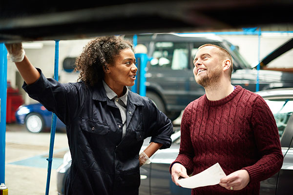 Female mechanic consulting with customer