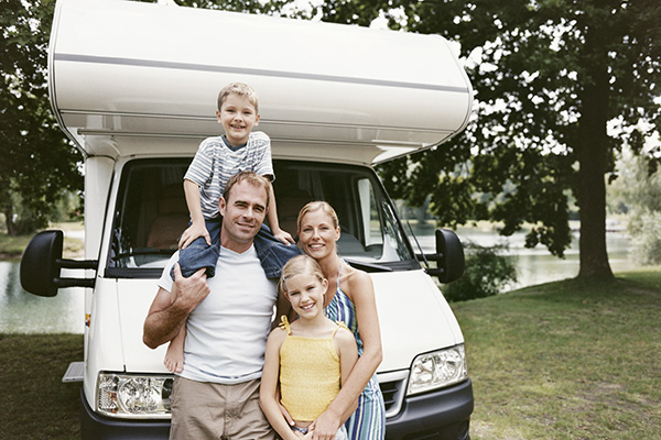 Family posing in front of RV camper
