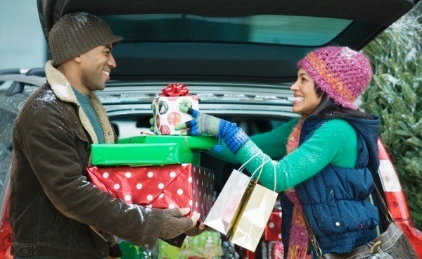 couple loading holiday gifts into car
