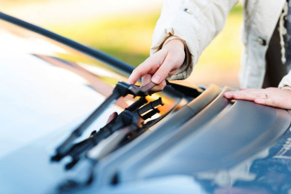 woman examining windshield wiper