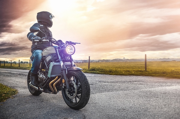 motorcycle parked on rural road at sunset