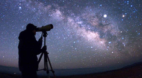 man star gazing with telescope