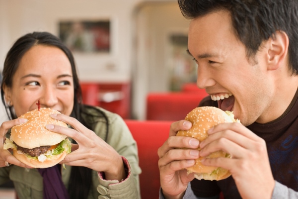 couple eating hamburgers at diner